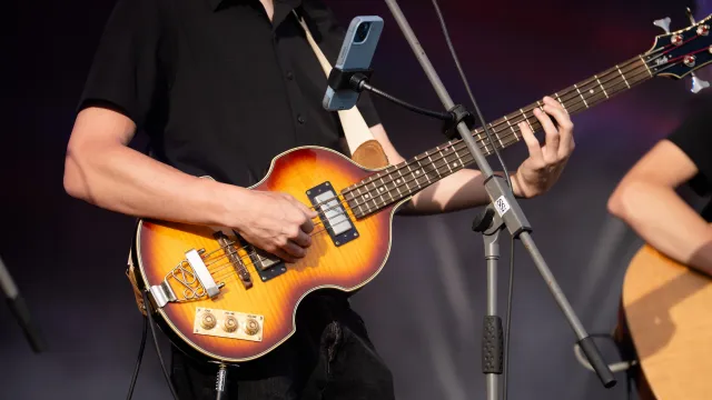 A man playing a vintage Hofner Violin bass guitar.