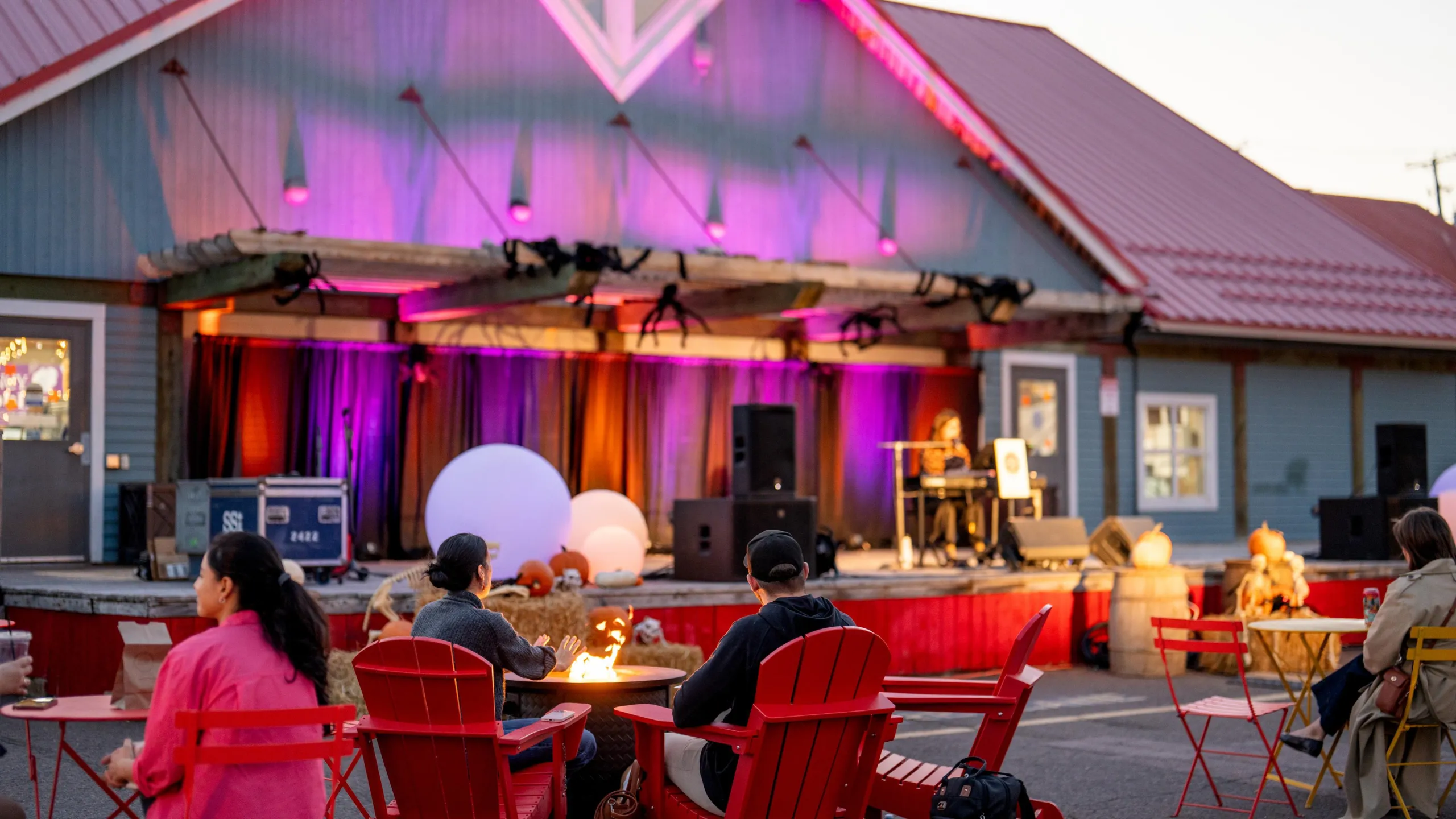 Couple sitting in front of a fire and watching live music at the Moncton Market
